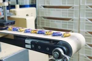 Jueves, 14 de marzo de 2024 8 Wrapped Candies Lying On Conveyor. Candy Factory